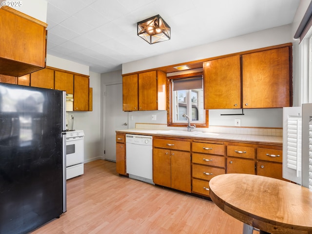 3128 SE 64th Ave, Portland, OR 97206 - kitchen with white appliances, brown cabinets, light countertops, and light wood-style floors