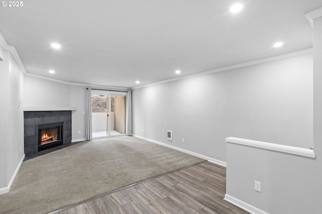 unfurnished living room with a tiled fireplace, hardwood / wood-style floors, and ornamental molding