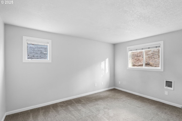 carpeted empty room featuring a textured ceiling