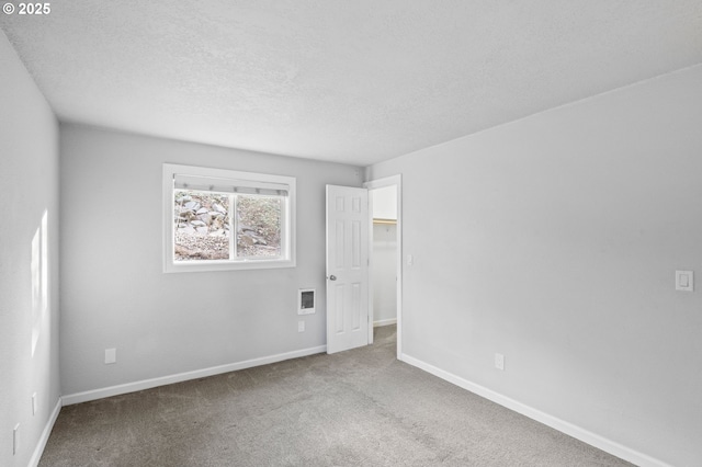 spare room featuring a textured ceiling and carpet