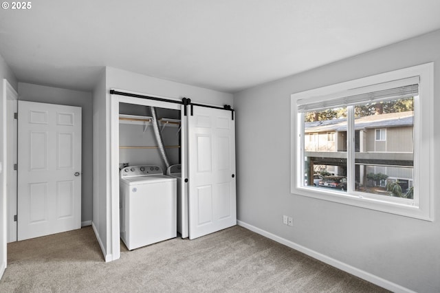 washroom with washer / clothes dryer, a barn door, and light carpet