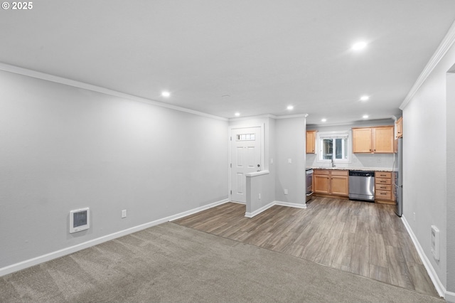 unfurnished living room with crown molding, carpet flooring, and sink