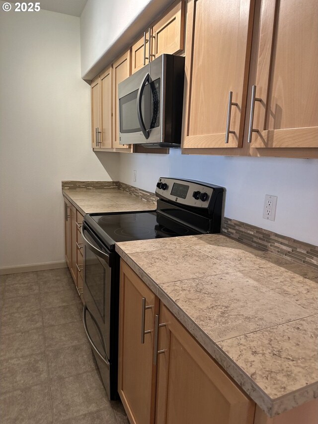 kitchen with stainless steel appliances and light brown cabinetry