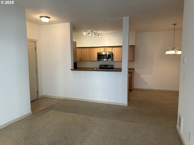 kitchen with an inviting chandelier, appliances with stainless steel finishes, carpet, and decorative light fixtures