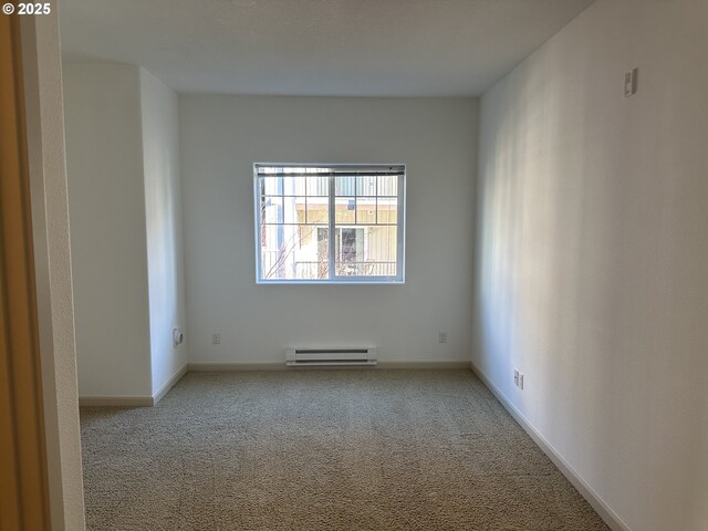 carpeted spare room with baseboard heating