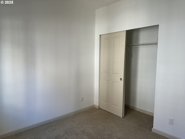 unfurnished bedroom with a closet and carpet flooring