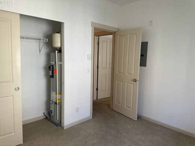 unfurnished bedroom with water heater, a closet, electric panel, and light carpet