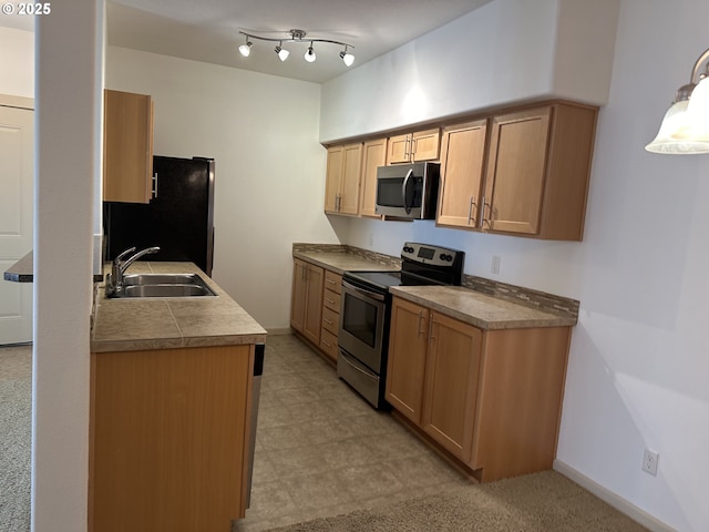 kitchen with sink, hanging light fixtures, and appliances with stainless steel finishes