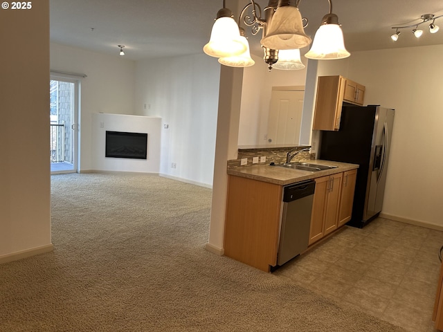 kitchen featuring appliances with stainless steel finishes, decorative light fixtures, light carpet, tasteful backsplash, and sink