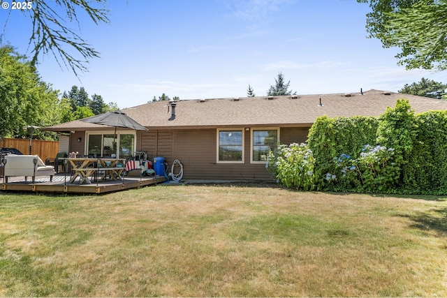 back of property with a wooden deck and a lawn