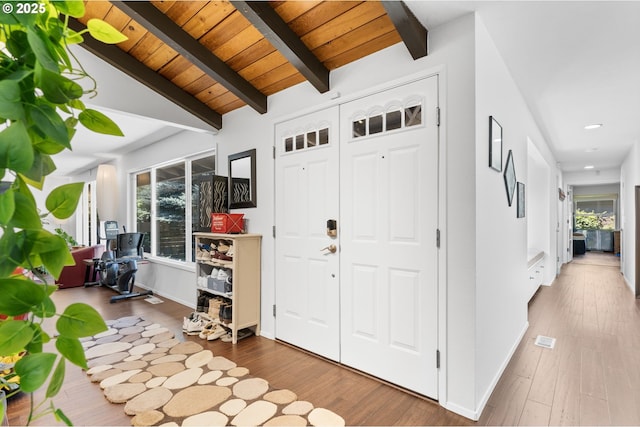 entrance foyer featuring wood-type flooring, lofted ceiling with beams, and wooden ceiling