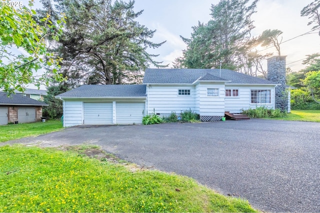 1756 NW 35th Pl, Lincoln City, OR 97367 - view of front facade with a garage, a shingled roof, a front yard, and asphalt driveway