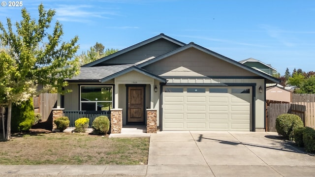 view of front of home featuring an attached garage, concrete driveway, and a shingled roof