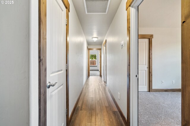 corridor featuring baseboards and wood finished floors