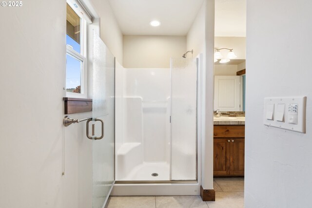 bathroom with a stall shower, tile patterned flooring, and vanity