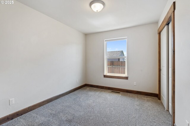 unfurnished bedroom featuring carpet flooring, baseboards, and a closet