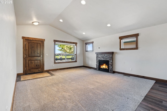 unfurnished living room with lofted ceiling, a fireplace, baseboards, and recessed lighting