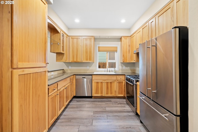 kitchen featuring appliances with stainless steel finishes, light hardwood / wood-style floors, light brown cabinets, and sink