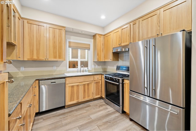 kitchen with light hardwood / wood-style floors, sink, light brown cabinets, stainless steel appliances, and light stone counters