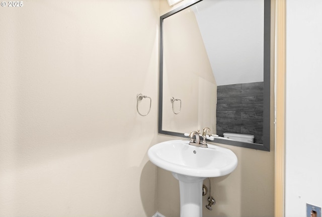 bathroom featuring toilet and lofted ceiling