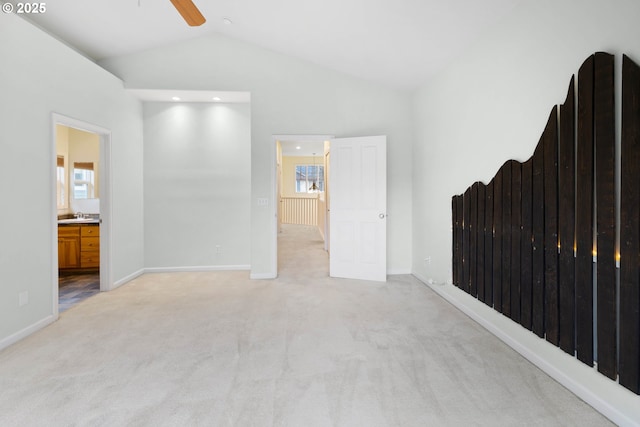 carpeted spare room featuring vaulted ceiling, ceiling fan, and sink