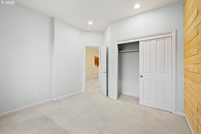 unfurnished bedroom featuring light colored carpet and a closet