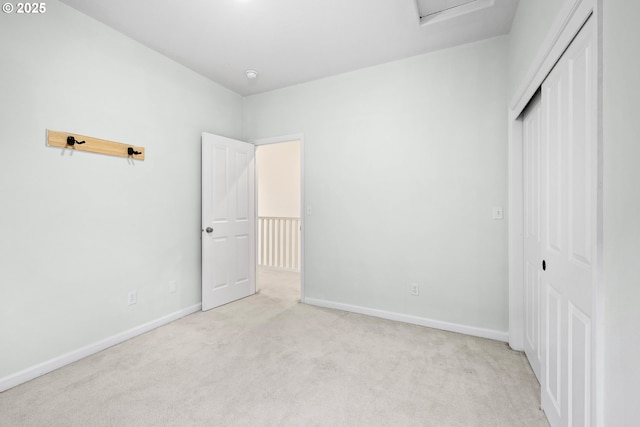 unfurnished bedroom featuring light colored carpet and a closet