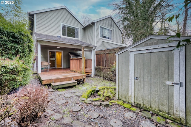 back of property with a wooden deck and a storage shed