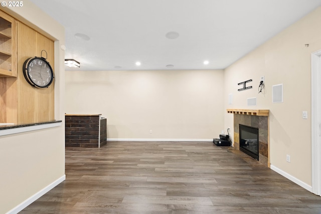 unfurnished living room with dark hardwood / wood-style floors and a tile fireplace