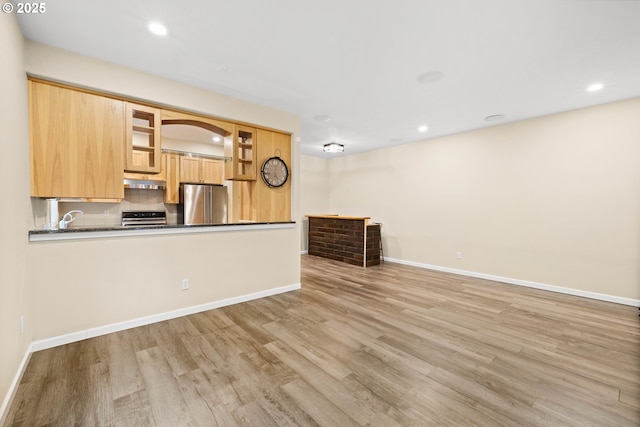 unfurnished living room with sink and light hardwood / wood-style floors