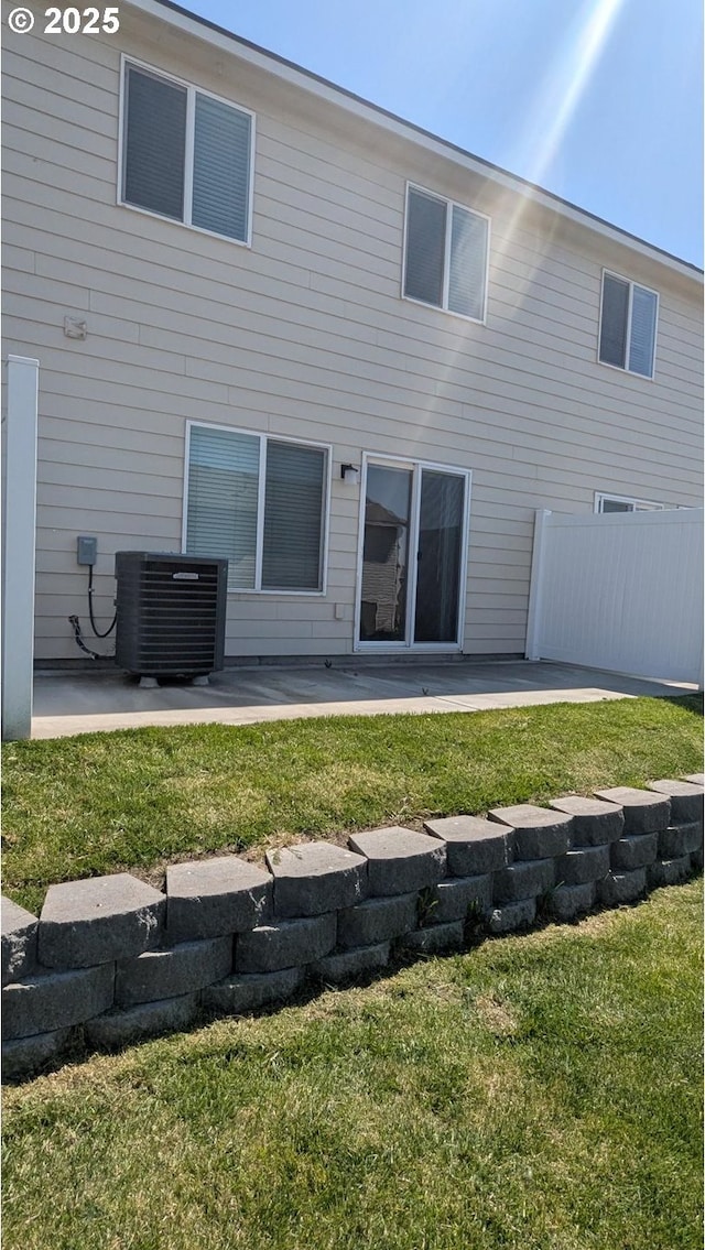 1745 NE 8th St, Hermiston, OR 97838 - rear view of house with central air condition unit, fence, a patio, and a lawn