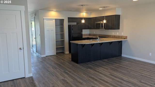 1745 NE 8th St, Hermiston, OR 97838 - kitchen with a sink, a kitchen breakfast bar, a peninsula, baseboards, and stainless steel microwave
