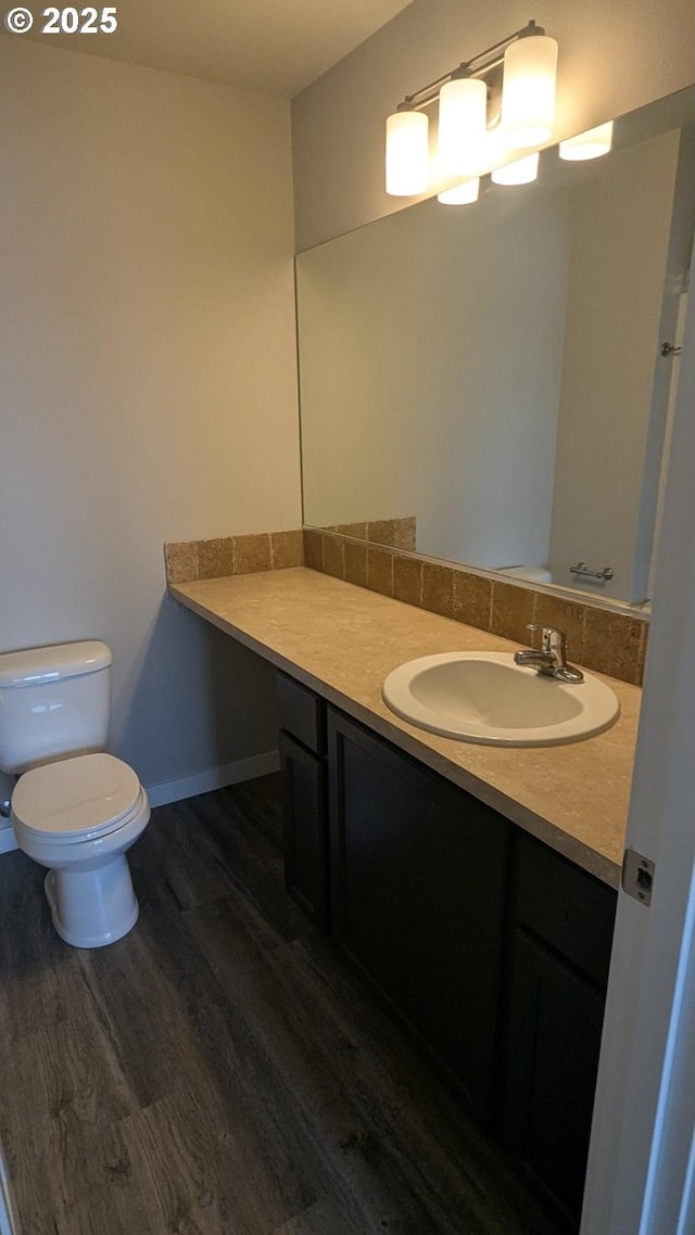 1745 NE 8th St, Hermiston, OR 97838 - bathroom featuring vanity, baseboards, toilet, and wood finished floors