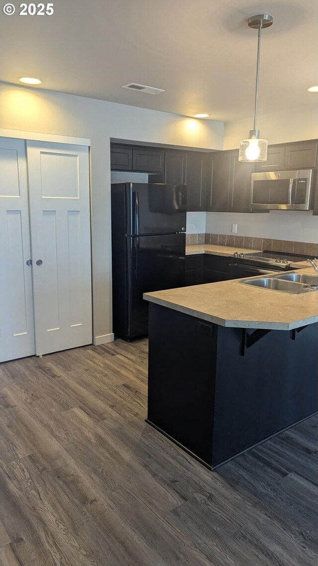 1745 NE 8th St, Hermiston, OR 97838 - kitchen featuring freestanding refrigerator, a breakfast bar area, dark wood-style floors, stainless steel microwave, and a sink