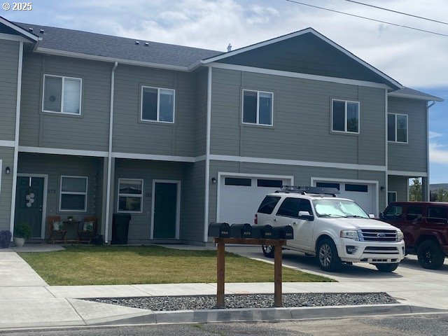 585 Baker St, Baker City, OR 97814 - view of front facade featuring driveway, an attached garage, and a front lawn