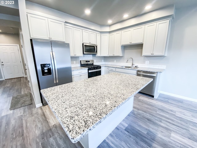 585 Baker St, Baker City, OR 97814 - kitchen featuring appliances with stainless steel finishes, light stone countertops, a kitchen island, light wood finished floors, and recessed lighting