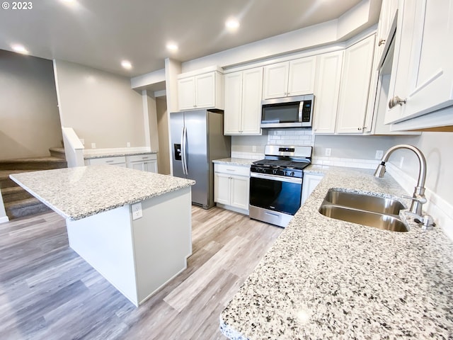 585 Baker St, Baker City, OR 97814 - kitchen featuring appliances with stainless steel finishes, a center island, light wood-style floors, light stone countertops, and recessed lighting