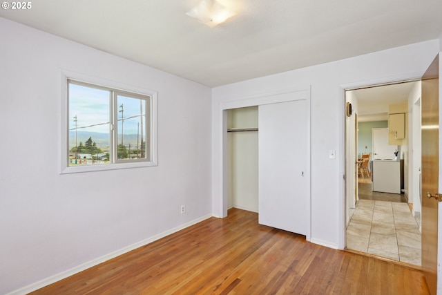1831 E 14th St, The Dalles, OR 97058 - unfurnished bedroom featuring washer / dryer, light wood-style floors, baseboards, and a closet