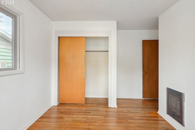 1831 E 14th St, The Dalles, OR 97058 - unfurnished bedroom featuring heating unit, light wood-type flooring, a closet, a fireplace, and baseboards
