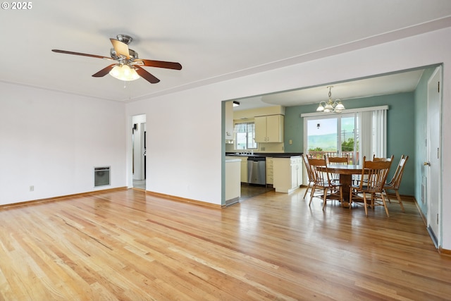 1831 E 14th St, The Dalles, OR 97058 - living room featuring light wood-style floors, heating unit, ceiling fan, a chandelier, and baseboards