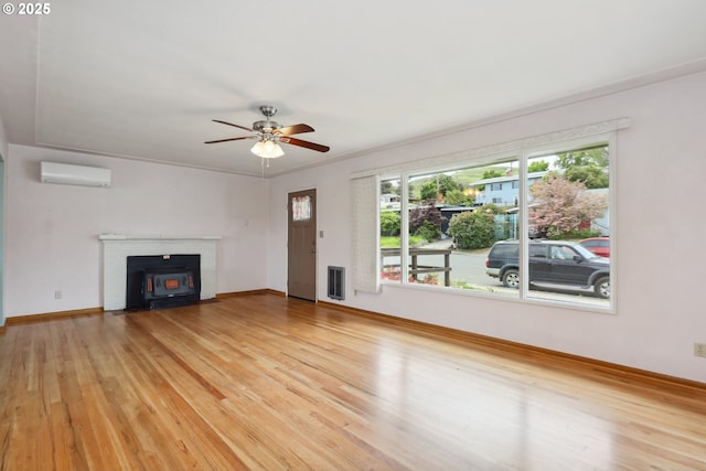 1831 E 14th St, The Dalles, OR 97058 - unfurnished living room with a ceiling fan, light wood-type flooring, a wall unit AC, and baseboards