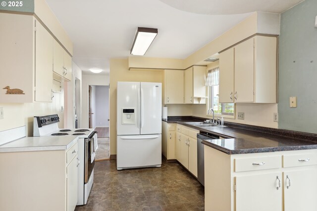 1831 E 14th St, The Dalles, OR 97058 - kitchen with white appliances, a sink, cream cabinetry, stone finish floors, and a peninsula
