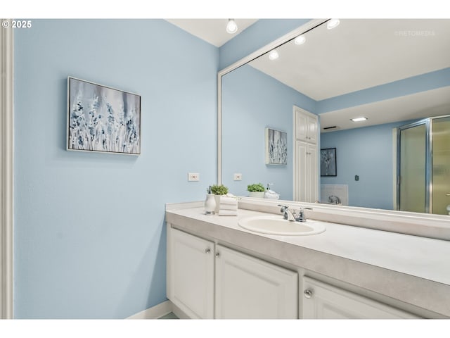full bathroom with vanity and a shower with shower door