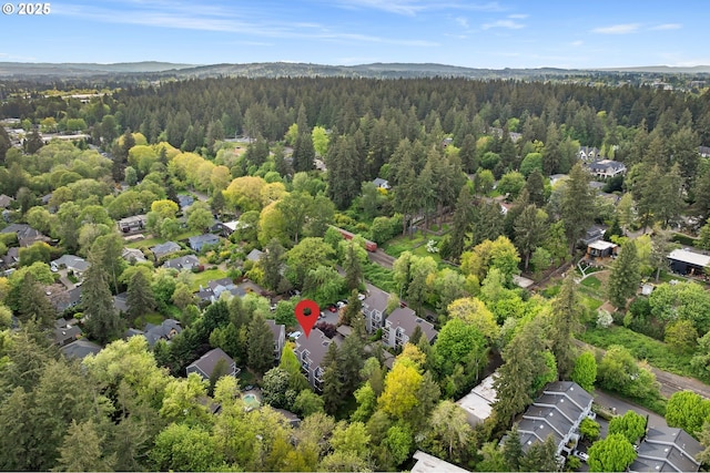 drone / aerial view featuring a residential view and a forest view