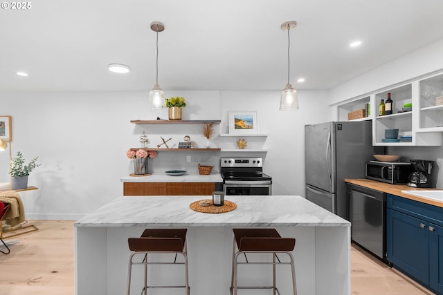 kitchen featuring open shelves, appliances with stainless steel finishes, a kitchen breakfast bar, and blue cabinetry