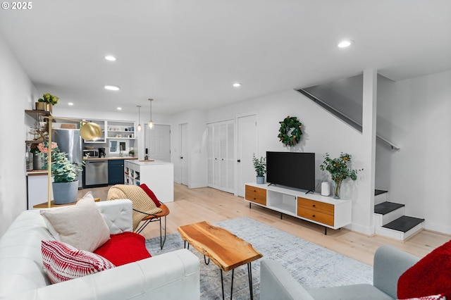living room with recessed lighting, baseboards, stairway, and light wood-style floors