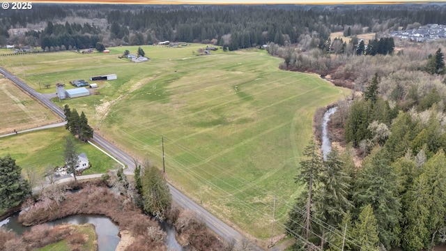 birds eye view of property with a view of trees and a rural view