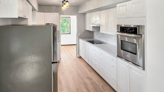 kitchen with light countertops, light wood-style floors, appliances with stainless steel finishes, under cabinet range hood, and white cabinetry