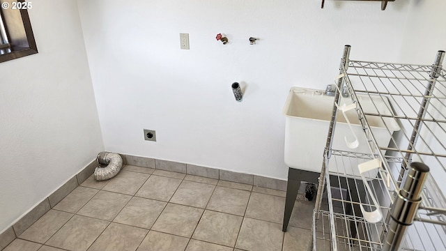 washroom with a sink, tile patterned floors, baseboards, and electric dryer hookup