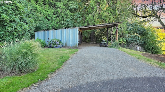 view of parking with gravel driveway and an outbuilding